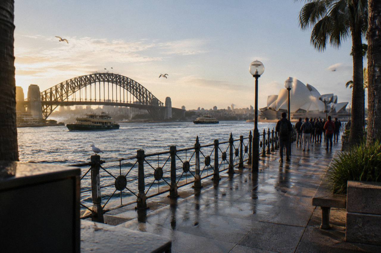 Sydney Opera House and harbour skyline seen from the water at golden hour
